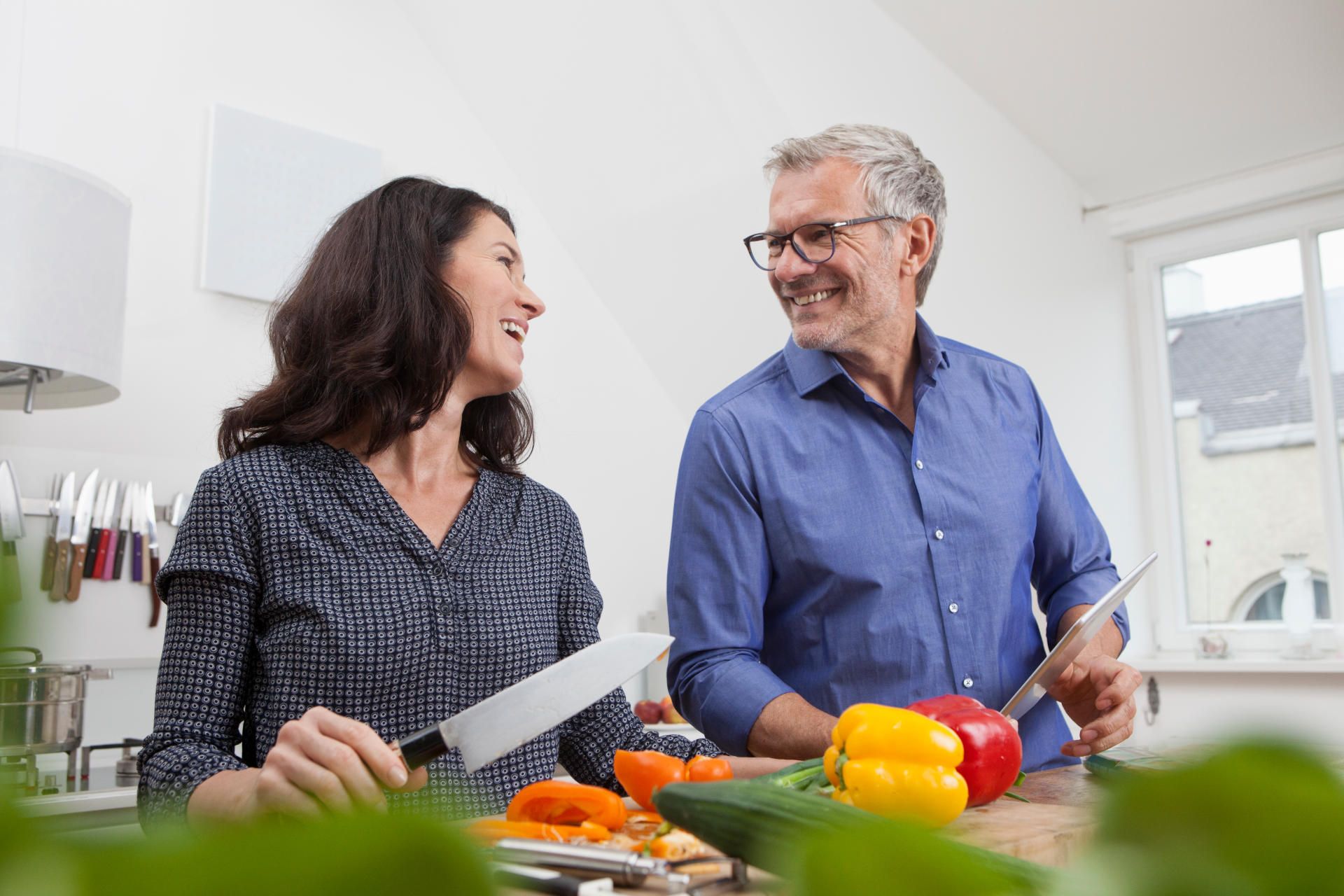 A middle-aged couple cooking a healthy meal